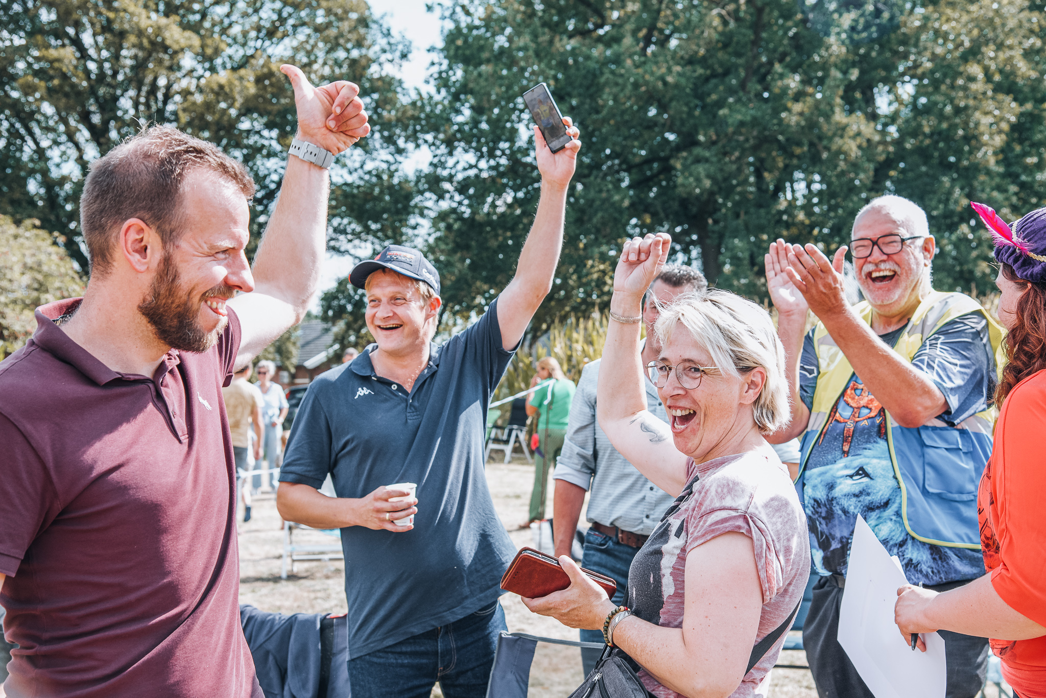 Bezoekers juichen met de handen omhoog tijdens het spel op het veld