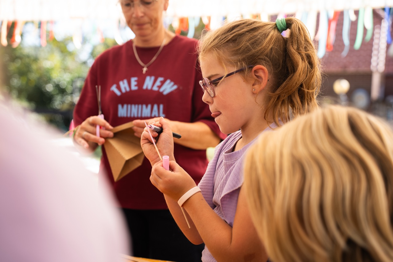 Meisjes knutselen met karton aan de knutseltafel tijdens de Kidsdag van Mozaiek0548