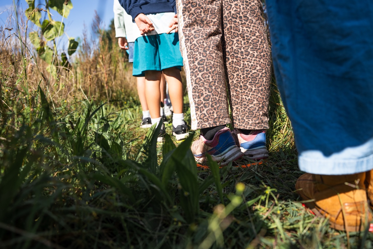 Kinderen lopen door het hoge gras tijdens een spel in het veld tijdens de Kidsdag van Mozaiek0548