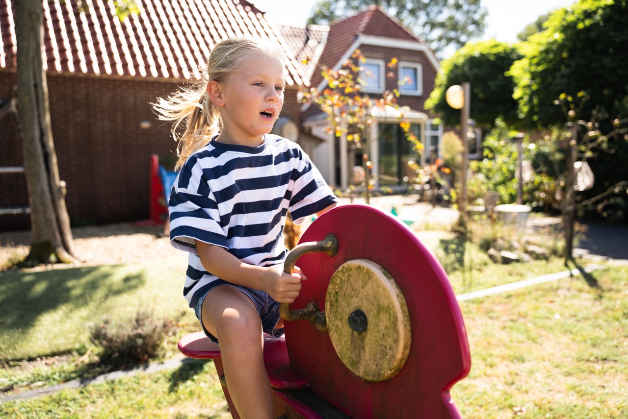 Meisje speelt op een speeltoestel in de tuin tijdens de Kidsdag van Mozaiek0548